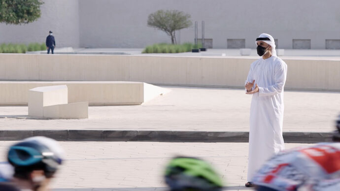 Khaled bin Mohamed bin Zayed greets cyclists riding through Abu Dhabi in the seventh stage of the UAE Tour